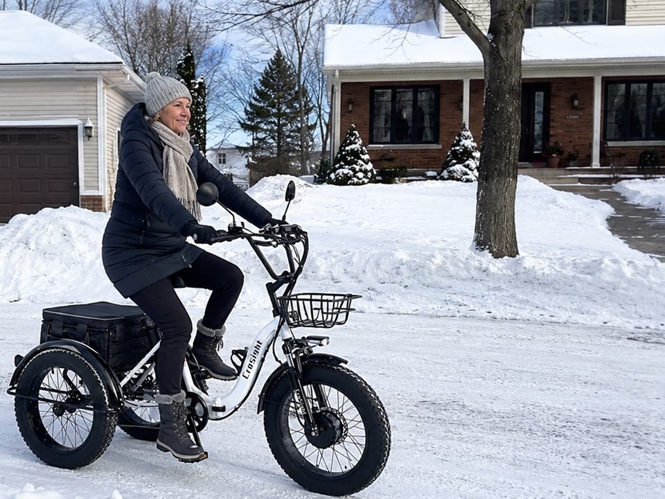 CroSight customer riding a white electric trike on a snowy neighborhood street.